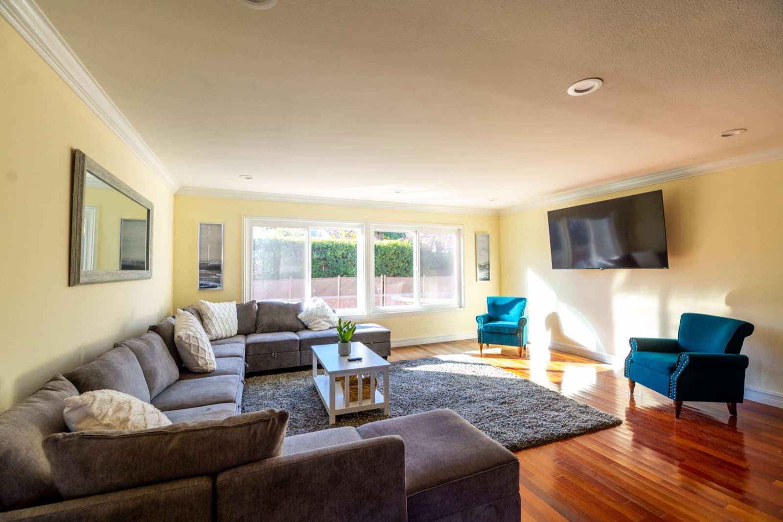 The living room, with a sectional sofa and teal armchairs